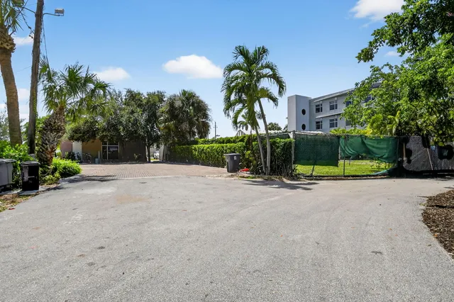 a view of a house with a yard and palm trees