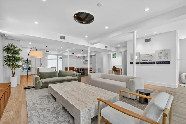 a living room with furniture and a view of kitchen