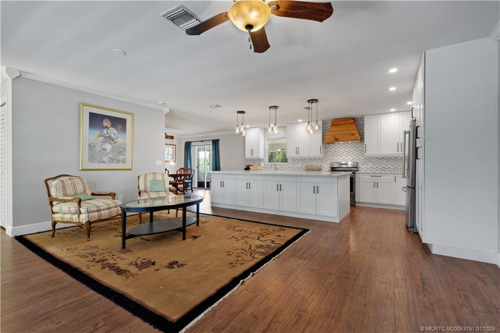 2916 Southeast Paramount Place Stuart, FL 34997 - Photo 14 of 38 a living room with kitchen island furniture and a wooden floor