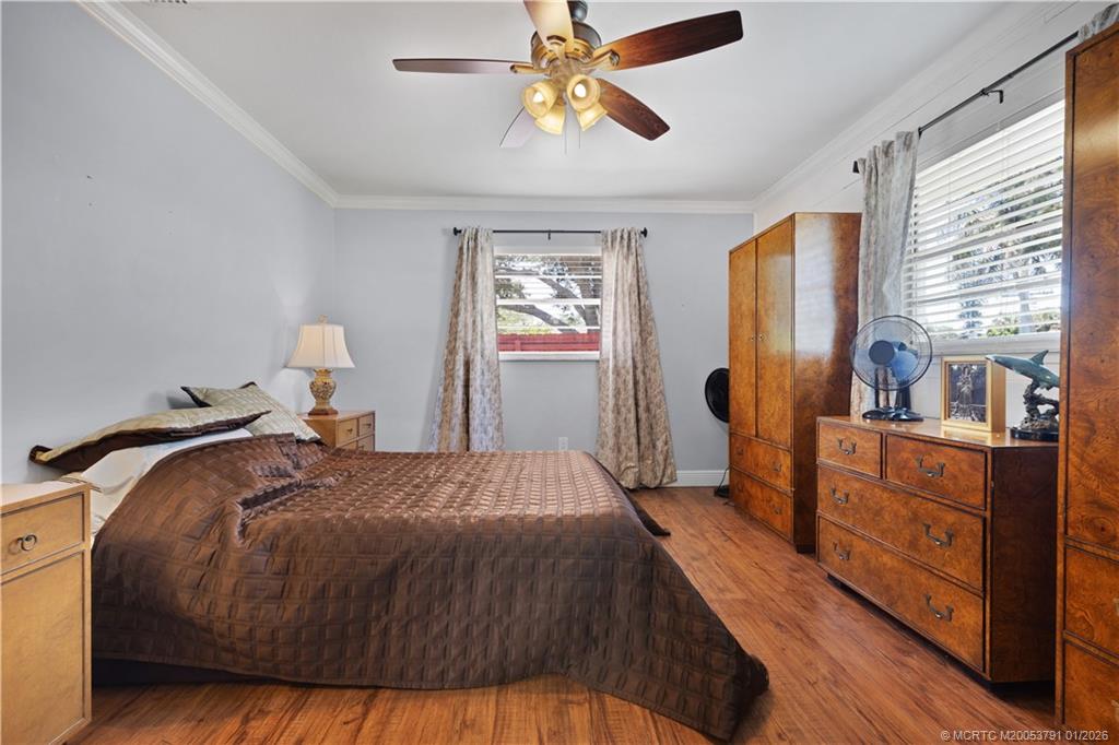 2916 Southeast Paramount Place Stuart, FL 34997 - Photo 15 of 38 a bedroom with a bed and a chandelier