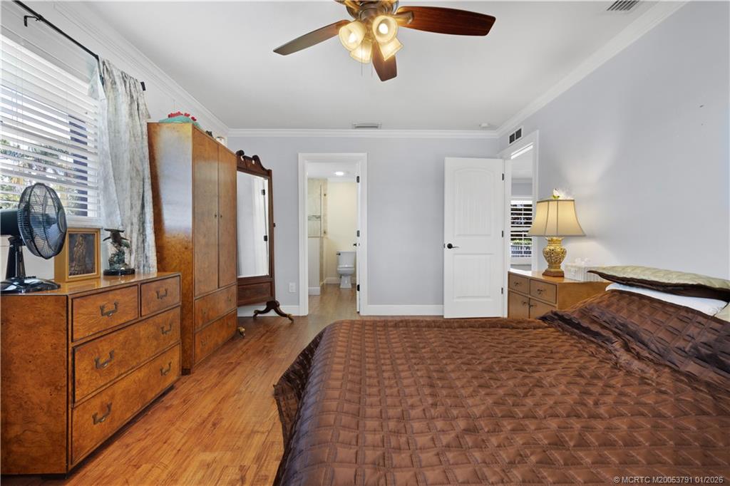 2916 Southeast Paramount Place Stuart, FL 34997 - Photo 16 of 38 a bedroom with a bed and a chandelier