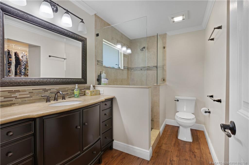 2916 Southeast Paramount Place Stuart, FL 34997 - Photo 17 of 38 a bathroom with a sink a toilet a large mirror and shower
