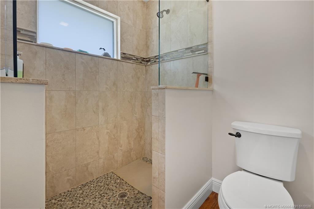 2916 Southeast Paramount Place Stuart, FL 34997 - Photo 18 of 38 a bathroom with a toilet and a shower