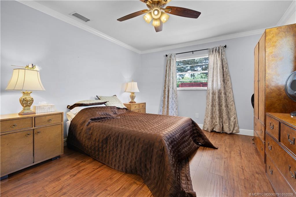 2916 Southeast Paramount Place Stuart, FL 34997 - Photo 20 of 38 a bedroom with a bed and a chandelier