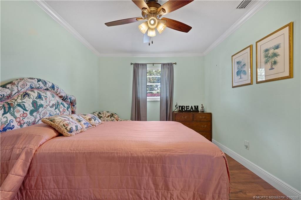 2916 Southeast Paramount Place Stuart, FL 34997 - Photo 23 of 38 a bedroom with a bed and a chandelier