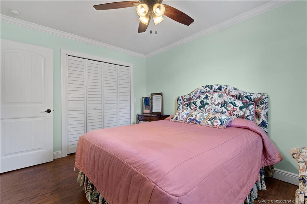 2916 Southeast Paramount Place Stuart, FL 34997 - Photo 24 of 38 a bedroom with a bed and a chandelier