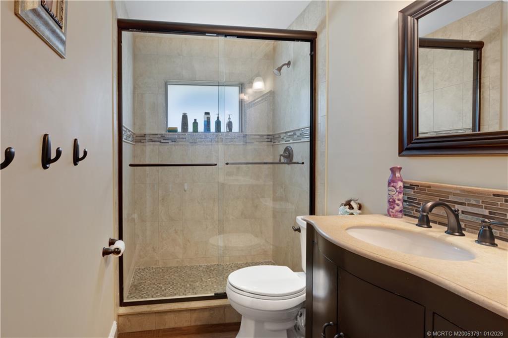 2916 Southeast Paramount Place Stuart, FL 34997 - Photo 25 of 38 a bathroom with a sink a toilet and shower