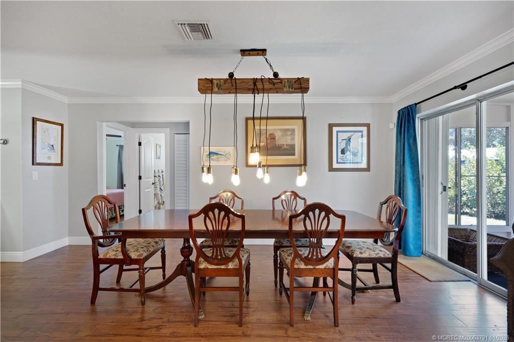 2916 Southeast Paramount Place Stuart, FL 34997 - Photo 3 of 38 a view of a dining room with furniture and wooden floor