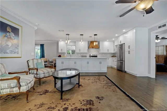 a room with stainless steel appliances kitchen island granite countertop furniture and a view of kitchen