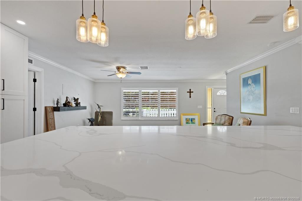 2916 Southeast Paramount Place Stuart, FL 34997 - Photo 8 of 38 a large bedroom with a bed and a chandelier