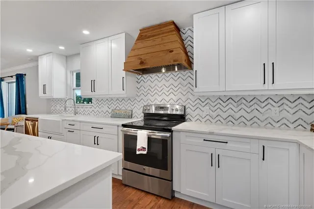 a kitchen with white cabinets and sink