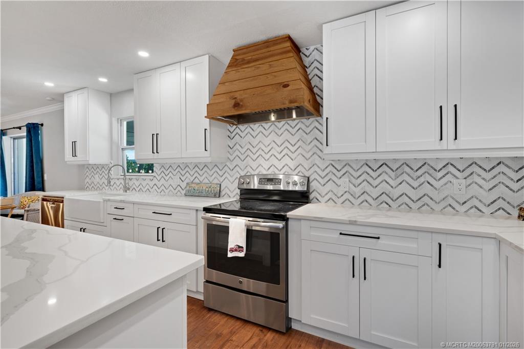 2916 Southeast Paramount Place Stuart, FL 34997 - Photo 9 of 38 a kitchen with white cabinets and sink