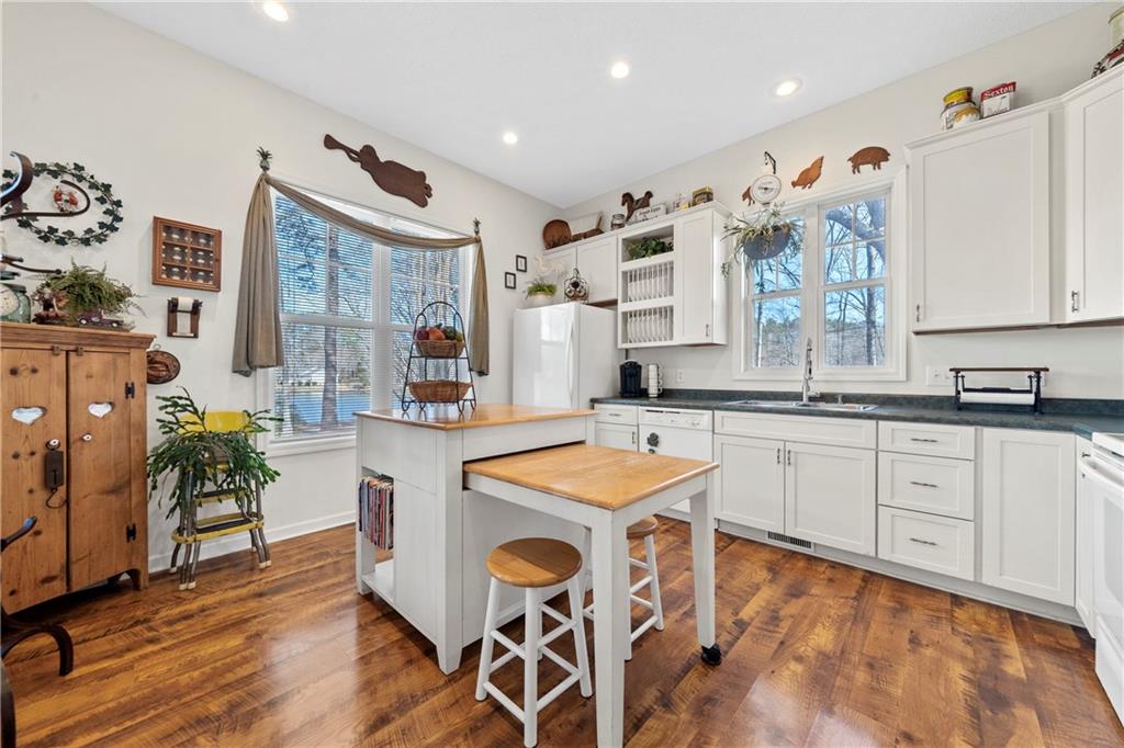 125 Lowe Road Northwest Milledgeville, GA 31061 - Photo 10 of 62 a large kitchen with granite countertop a sink and white cabinets with wooden floor