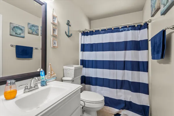 a bathroom with a sink a toilet and shower curtain