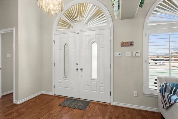 an empty room with wooden floor cabinet and windows