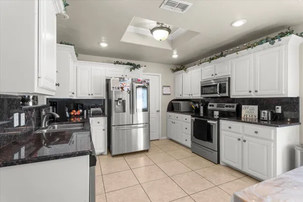 a kitchen with granite countertop a refrigerator and a sink