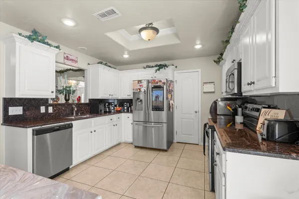 a kitchen with stainless steel appliances granite countertop a sink and a refrigerator