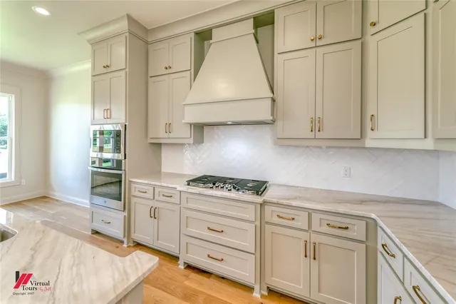 a kitchen with granite countertop a sink cabinets stainless steel appliances and a couch