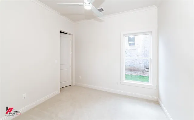 an empty room with an entryway and fan