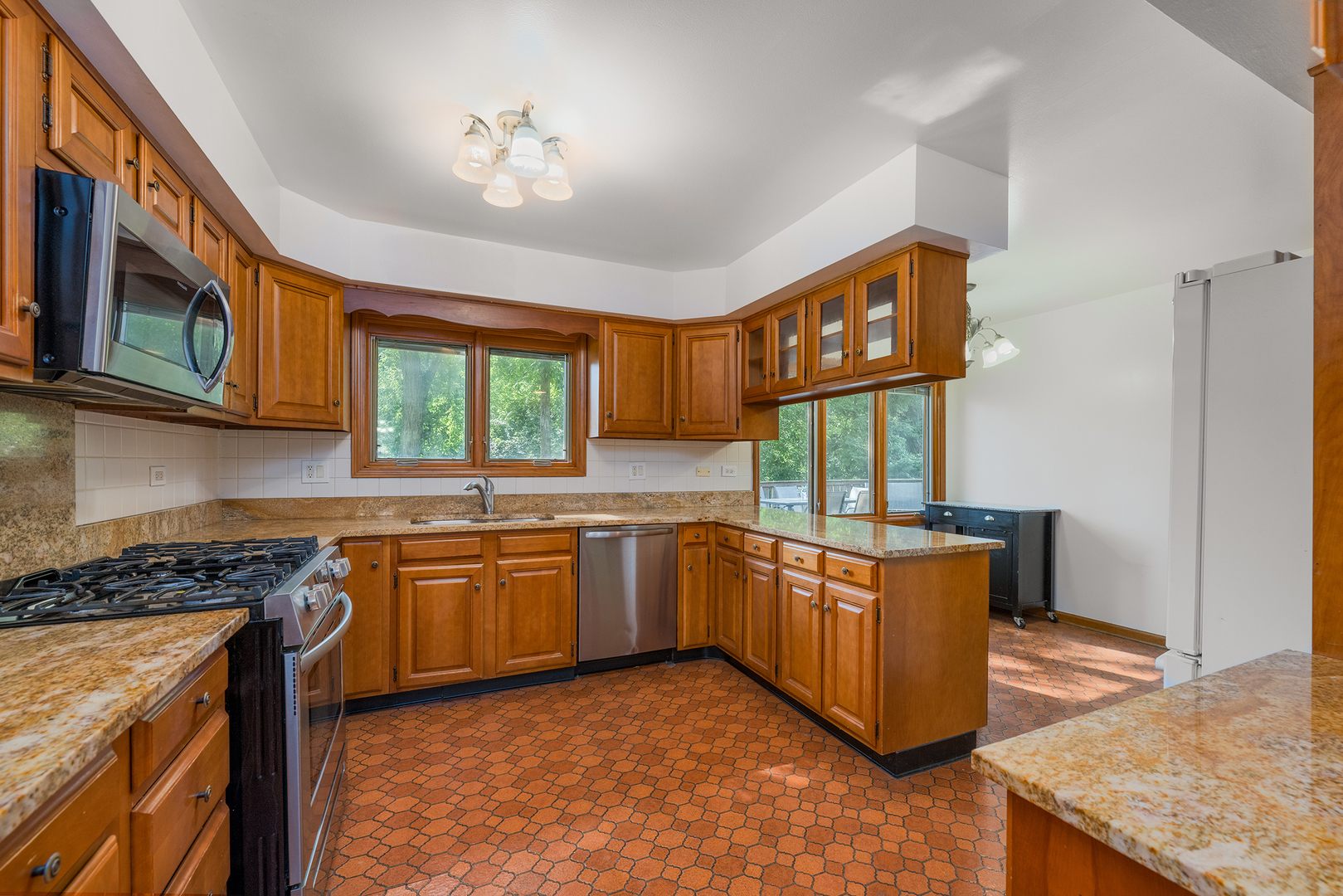900 Ruth Drive Elgin, IL 60123 - Photo 6 of 25 a kitchen with stainless steel appliances granite countertop wooden cabinets a stove a sink and a refrigerator