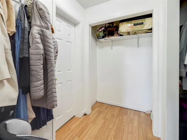 a view of walk in closet with clothes and shoes