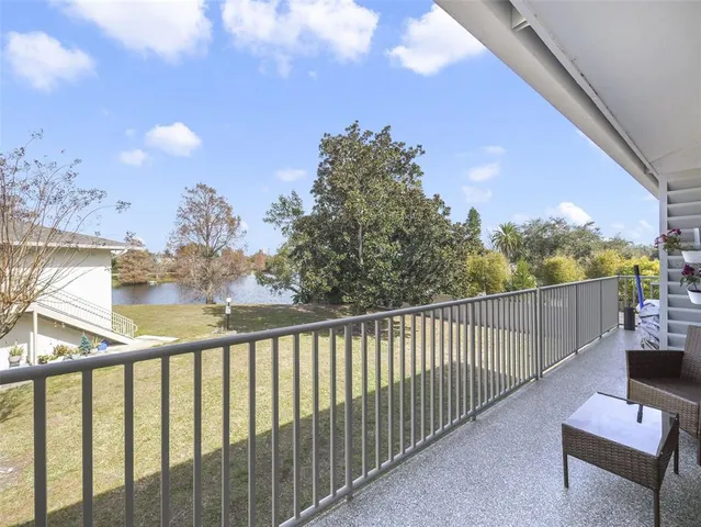 a view of a balcony with wooden floor and fence