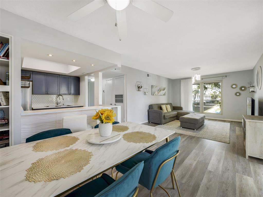 1935 South Conway Road, Unit F5 Orlando, FL 32812 - Photo 5 of 20 a kitchen with stainless steel appliances granite countertop a stove a sink dishwasher a dining table and chairs with wooden floor