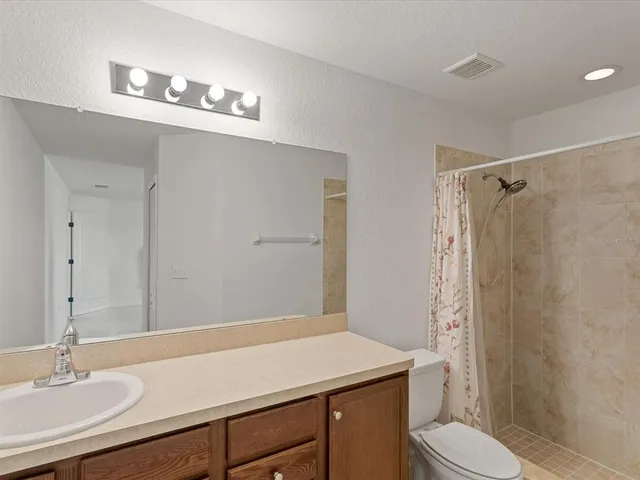 a bathroom with a sink a toilet a shower and a mirror