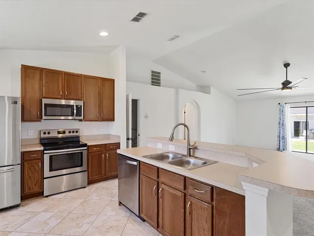 a kitchen with stainless steel appliances a sink stove and refrigerator