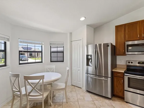 a kitchen with stainless steel appliances a refrigerator a stove a dining table and chairs