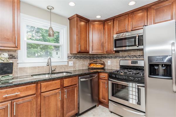 a kitchen with stainless steel appliances a stove sink microwave and cabinets