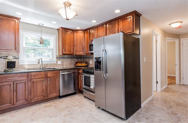 185 Redlands Street Springfield, MA 01104 - Photo 13 of 28 a kitchen with stainless steel appliances granite countertop a refrigerator a sink a stove a washer dryer and a window