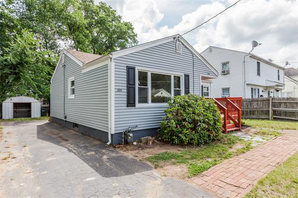 185 Redlands Street Springfield, MA 01104 - Photo 3 of 28 a view of a house with a yard and lawn chairs with wooden fence