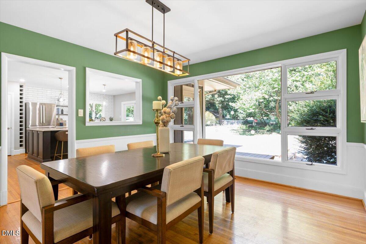 1401 Spring Forest Road Raleigh, NC 27615 - Photo 13 of 47 a dining room with furniture a chandelier and wooden floor