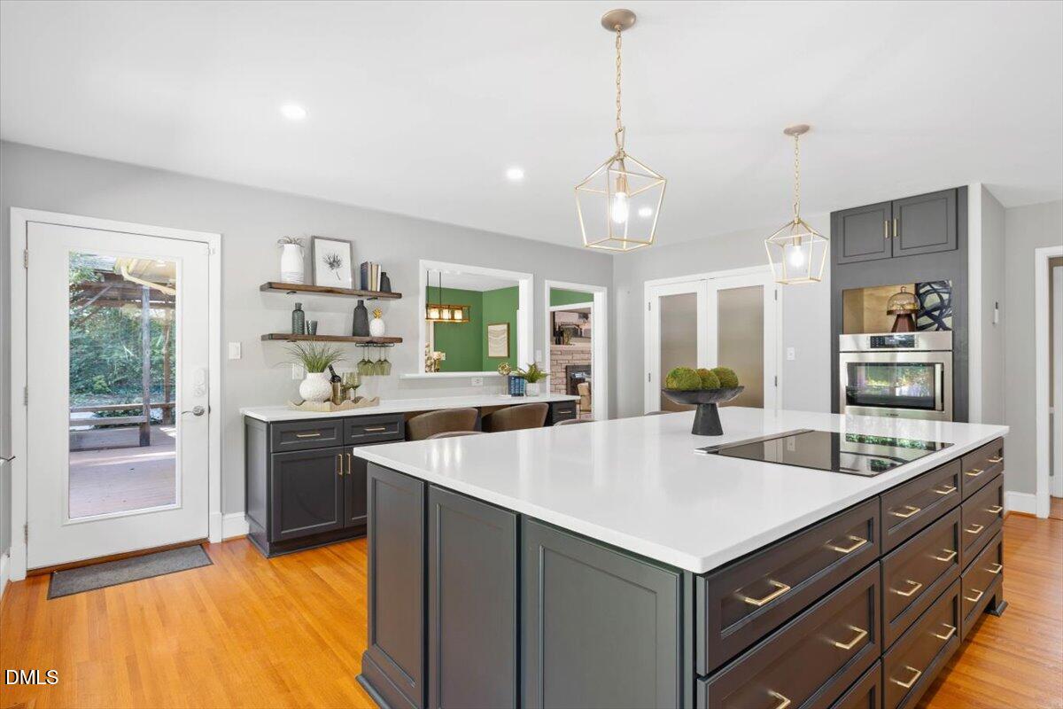 1401 Spring Forest Road Raleigh, NC 27615 - Photo 16 of 47 a large kitchen with kitchen island a large counter top space appliances and windows