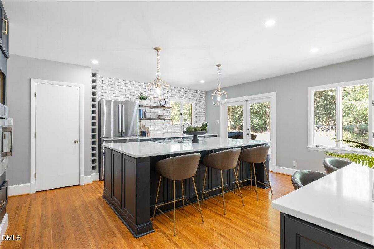 1401 Spring Forest Road Raleigh, NC 27615 - Photo 18 of 47 a kitchen with stainless steel appliances granite countertop a table chairs sink and wooden floor
