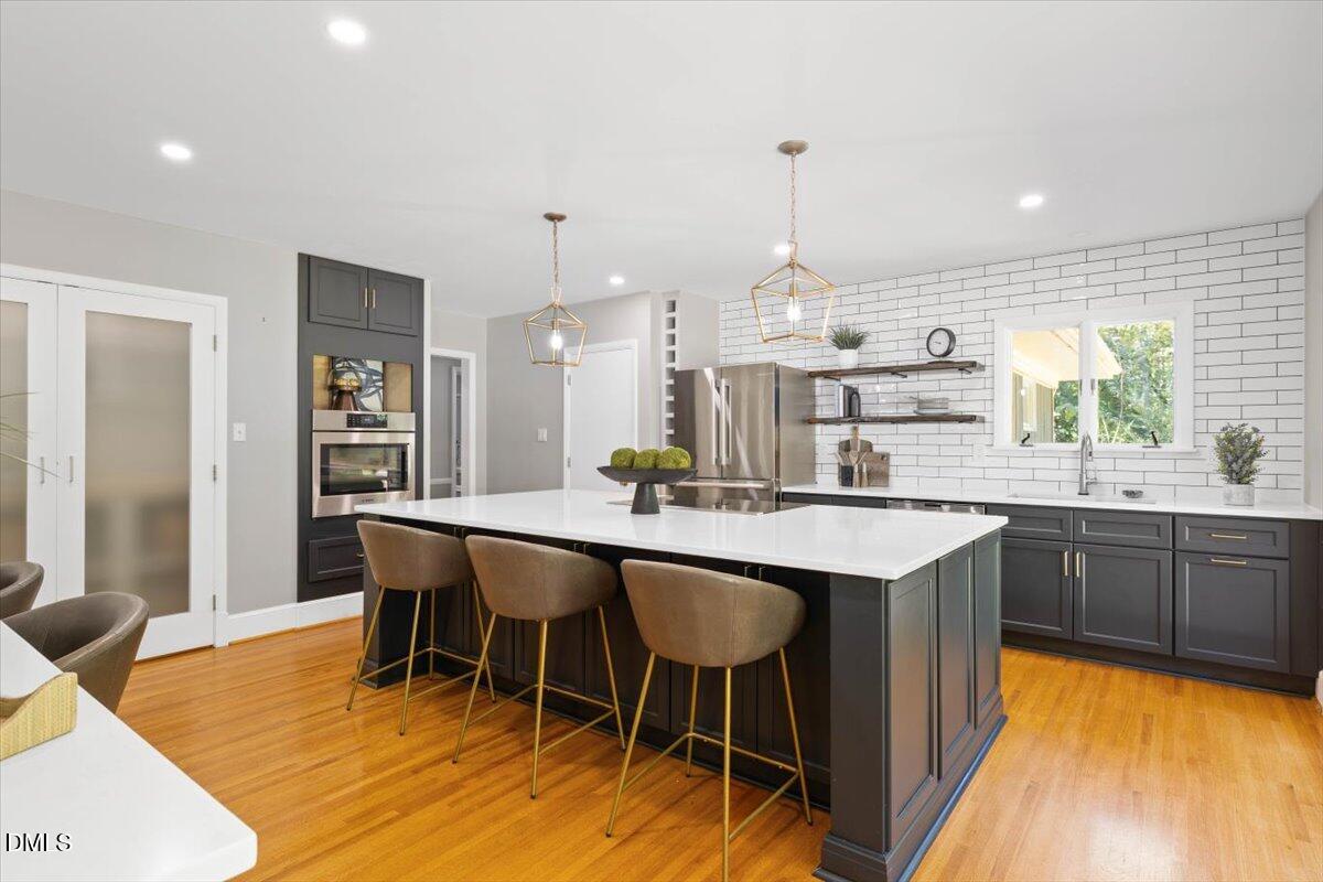 1401 Spring Forest Road Raleigh, NC 27615 - Photo 18 of 47 a kitchen with stainless steel appliances granite countertop a table chairs sink and cabinets