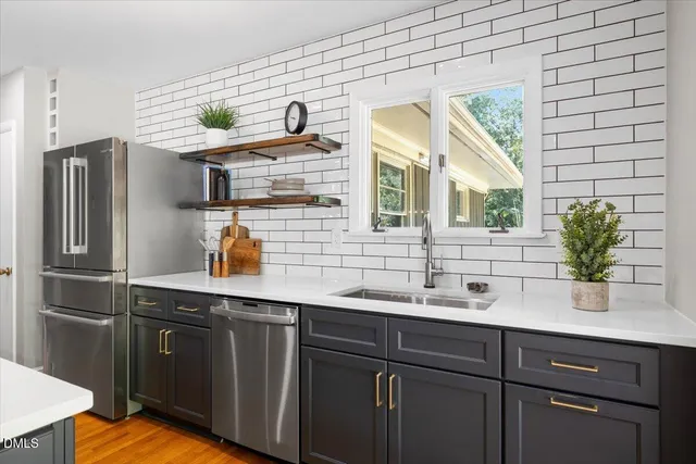 a kitchen with stainless steel appliances granite countertop a sink and wooden cabinets