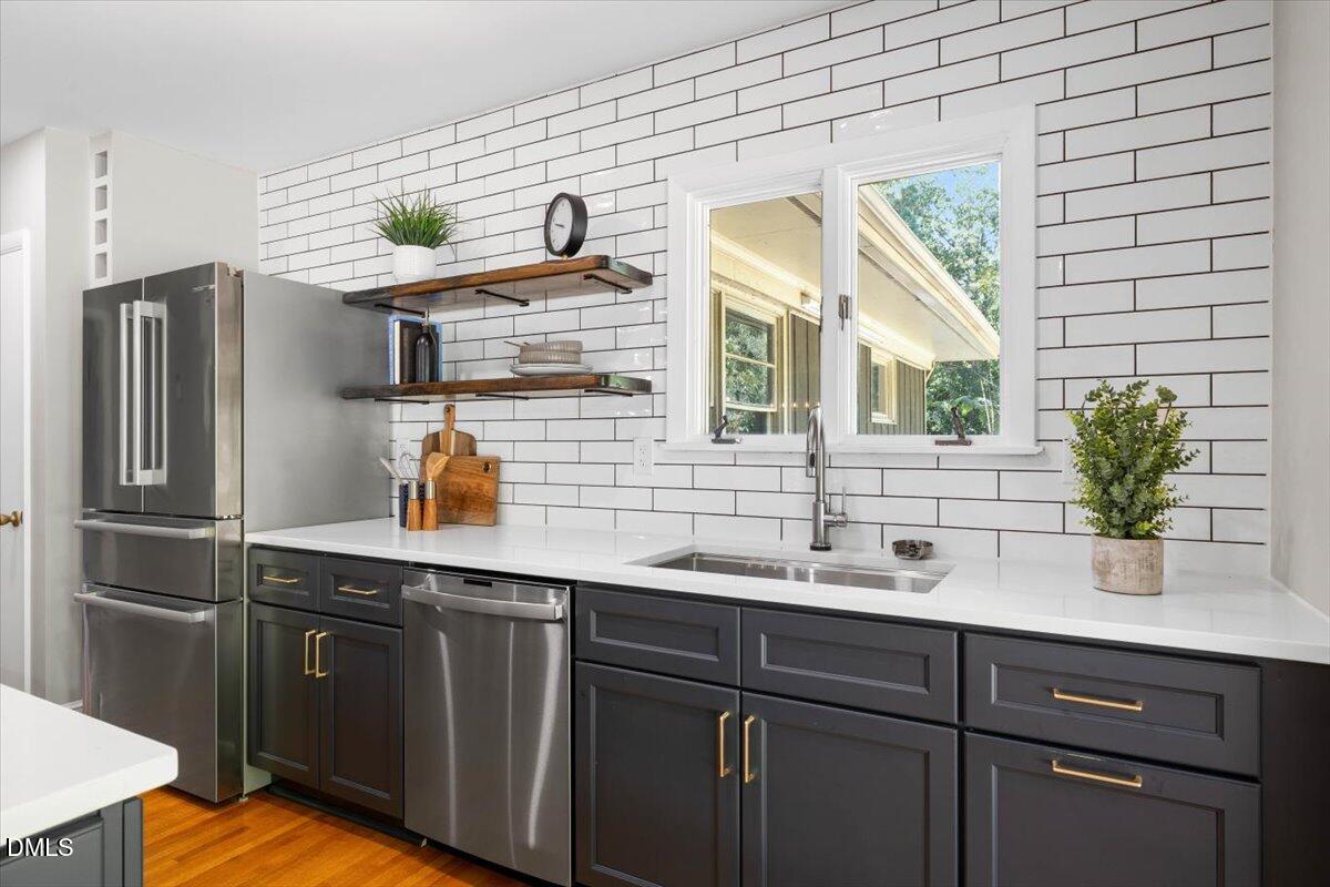 1401 Spring Forest Road Raleigh, NC 27615 - Photo 20 of 47 a kitchen with stainless steel appliances granite countertop a sink and wooden cabinets