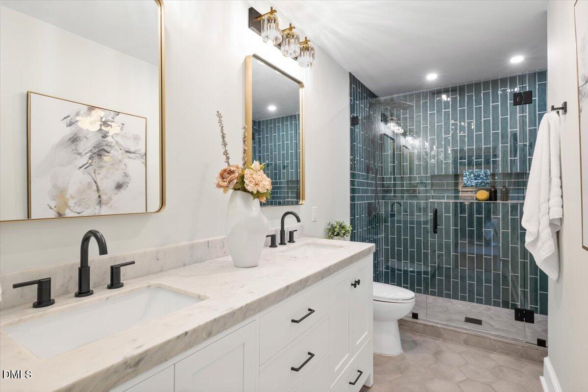 1401 Spring Forest Road Raleigh, NC 27615 - Photo 25 of 47 a bathroom with a sink mirror and toilet