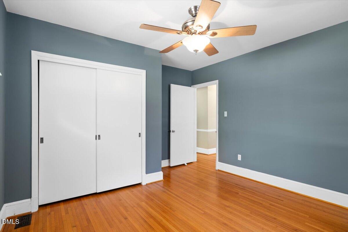 1401 Spring Forest Road Raleigh, NC 27615 - Photo 29 of 47 an empty room with wooden floor and fan