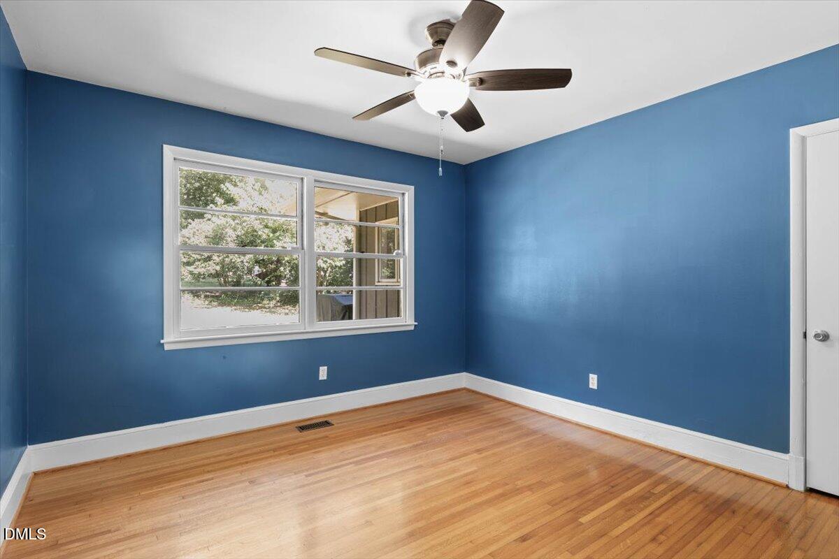 1401 Spring Forest Road Raleigh, NC 27615 - Photo 31 of 47 an empty room with a window and a ceiling fan