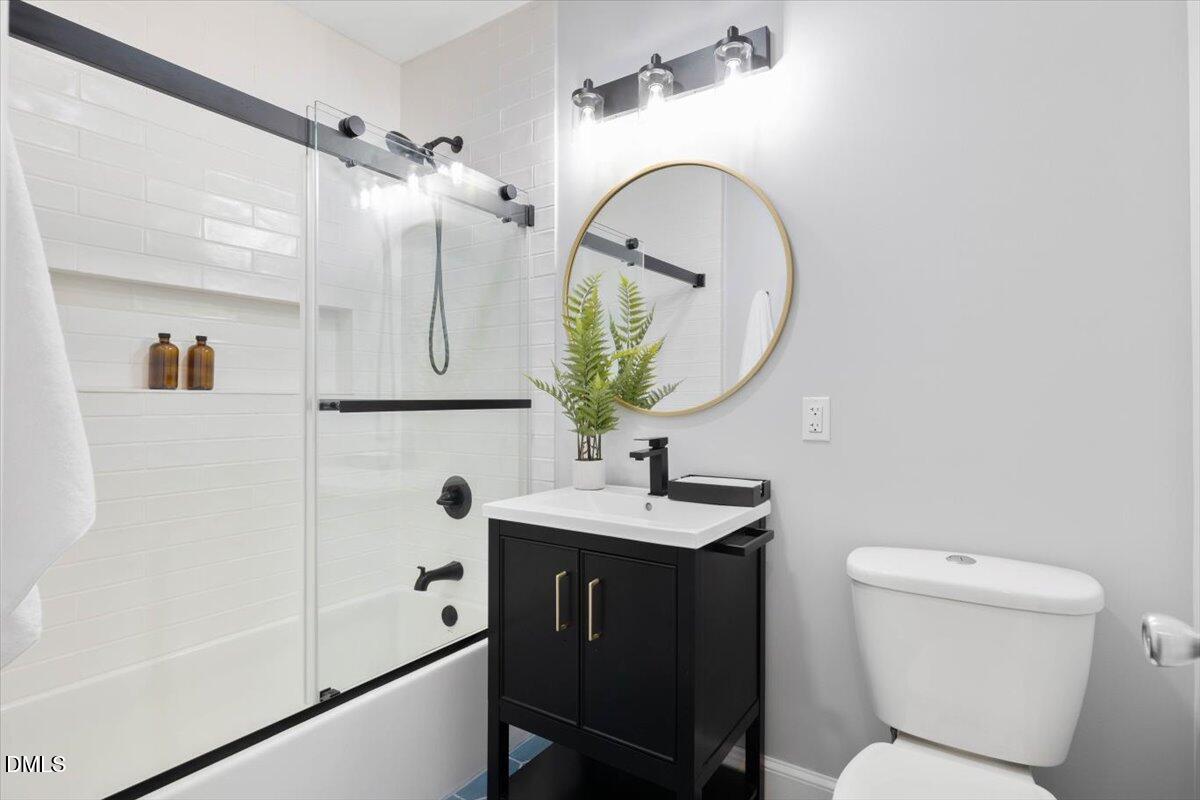1401 Spring Forest Road Raleigh, NC 27615 - Photo 33 of 47 a bathroom with a sink a toilet and a mirror