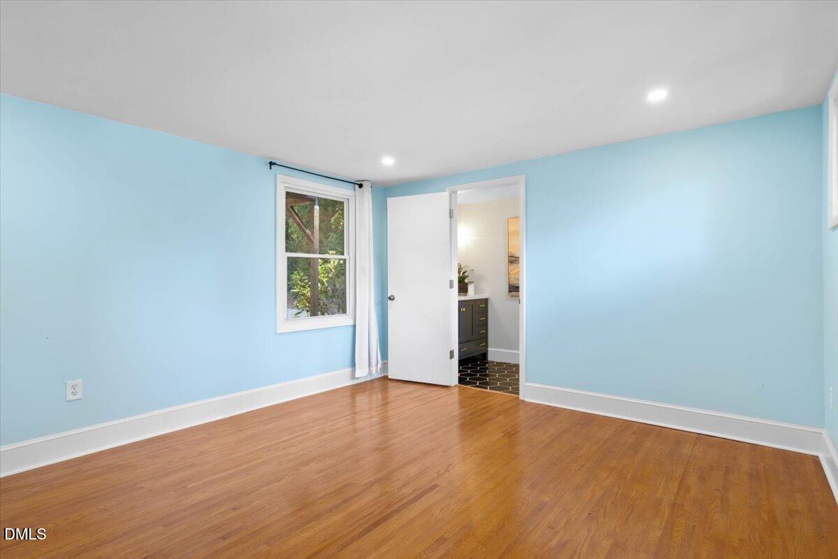1401 Spring Forest Road Raleigh, NC 27615 - Photo 35 of 47 a view of an empty room with wooden floor and a window