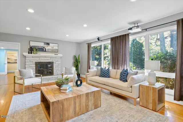 a living room with furniture large window and a fireplace