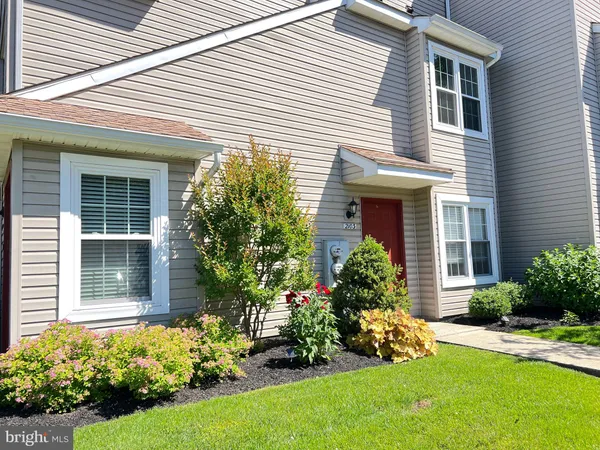 front view of a house with a yard and flowers