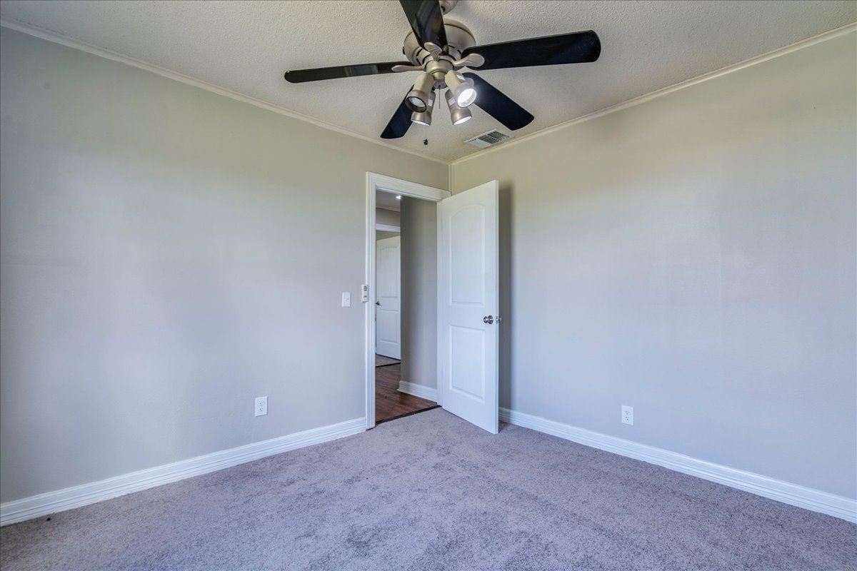 595 Cardinal Road Rosanky, TX 78953 - Photo 22 of 39 an empty room with a ceiling fan and carpet