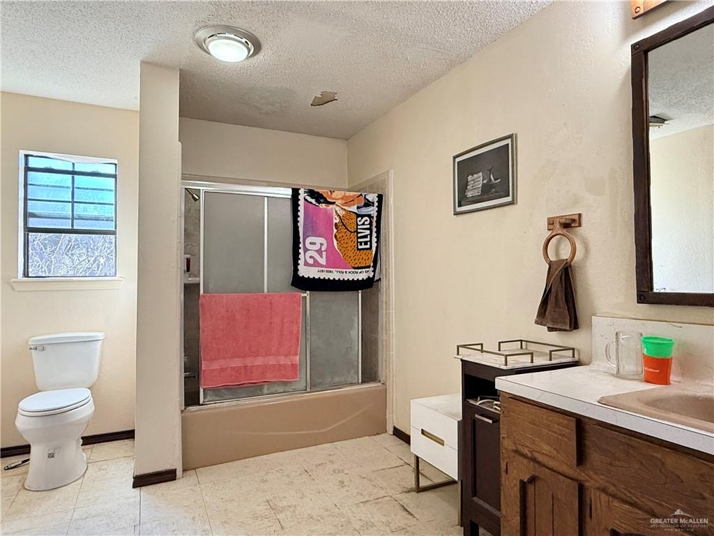 603 South Alamo Road Alamo, TX 78516 - Photo 12 of 17 a bathroom with a toilet sink and mirror