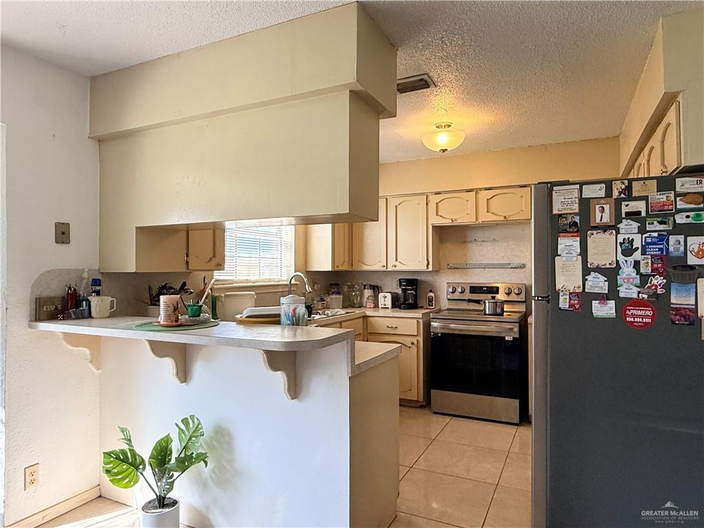 603 South Alamo Road Alamo, TX 78516 - Photo 5 of 17 a kitchen with stainless steel appliances granite countertop a sink a stove and a refrigerator