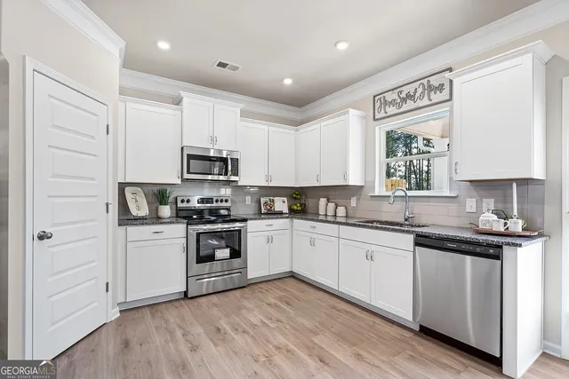 a kitchen with granite countertop white cabinets and white appliances